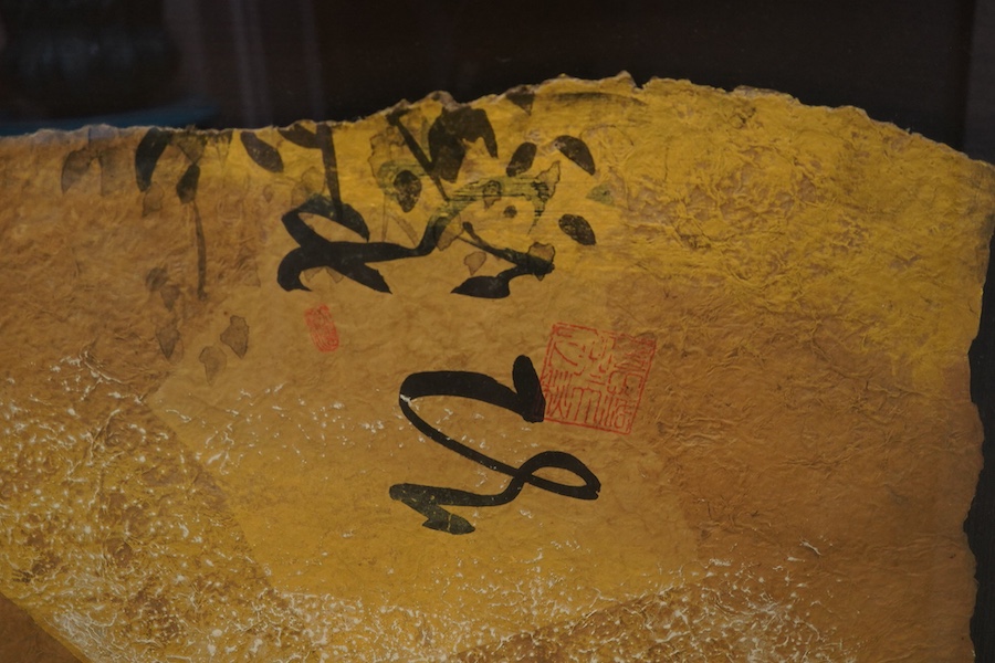 A large Japanese hand painted panel depicting figures before a landscape, framed, 88 x 104cm